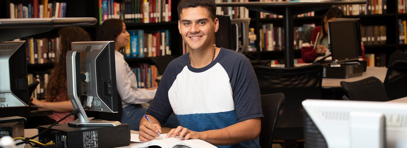 Student Smiles with Textbook