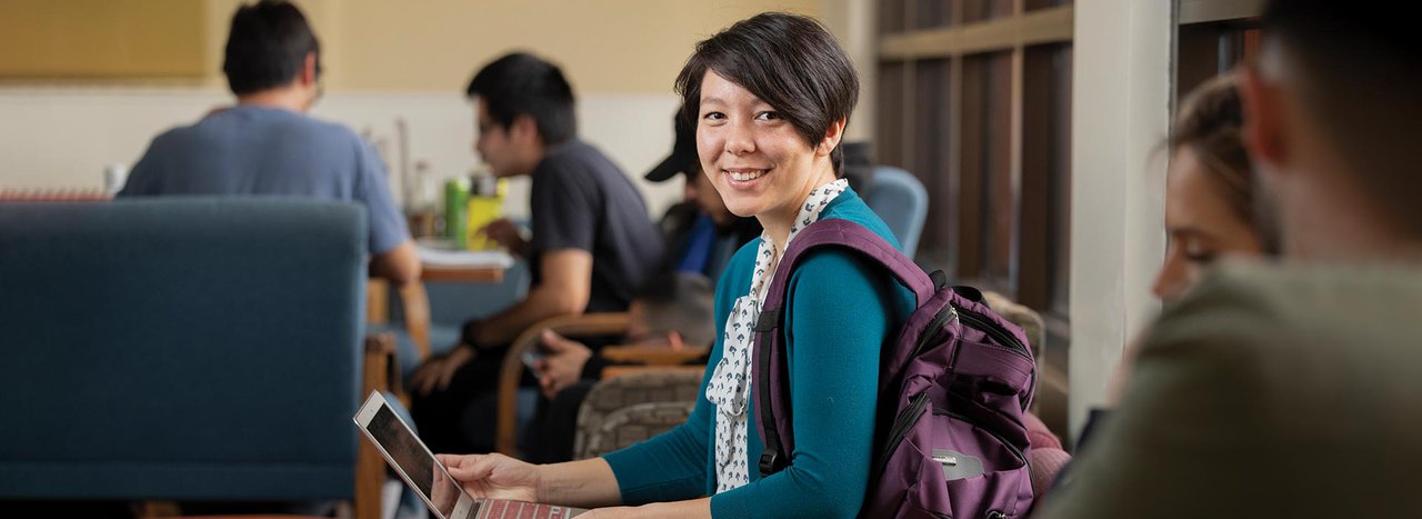 Female student smiling with laptop