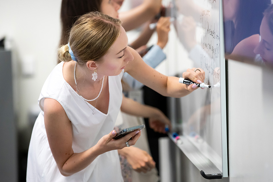 Anhelina Nedoshytko writes on white board.