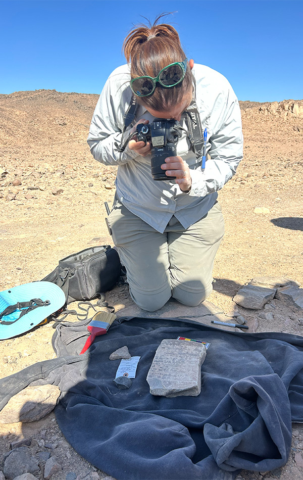 Student photographing excavated artifacts.