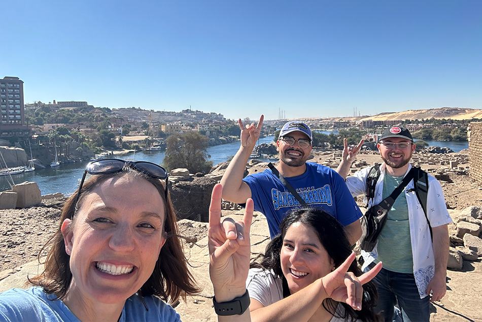 Kate Liszka and students hold up coyote hand signs in Egypt.