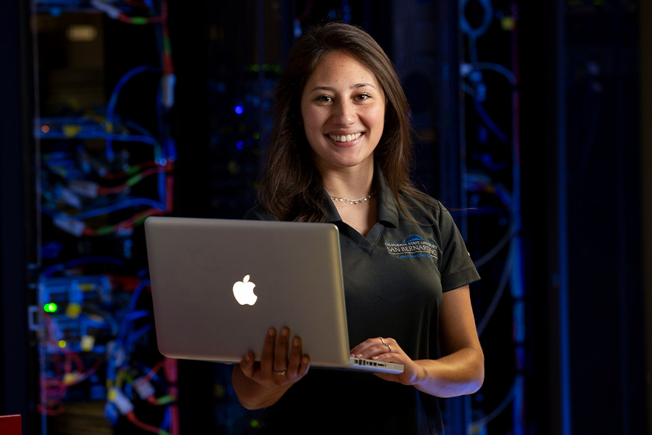 Student with laptop in server room.