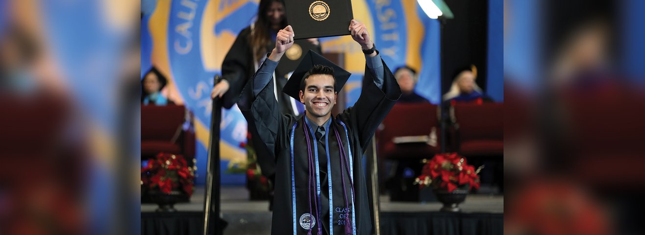 CSUSB graduate raises diploma in the air