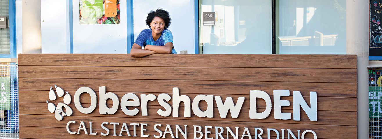 Student smiles outside the Obershaw DEN